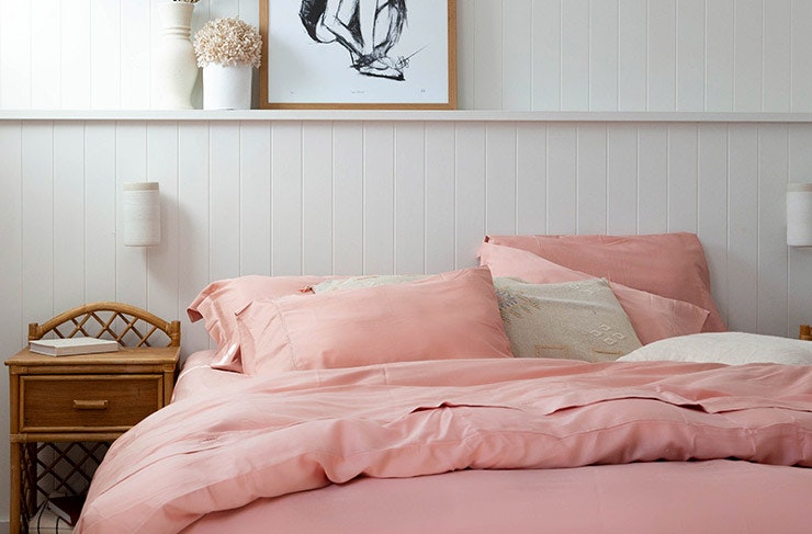 A bed made with pink bamboo sheets